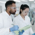 Dois cientistas colaboram em uma pesquisa dentro de um laboratório moderno.