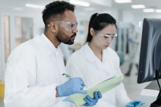 Dois cientistas colaboram em uma pesquisa dentro de um laboratório moderno.