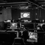 Pessoas jogam em computadores em um estúdio de jogos eletrônicos.