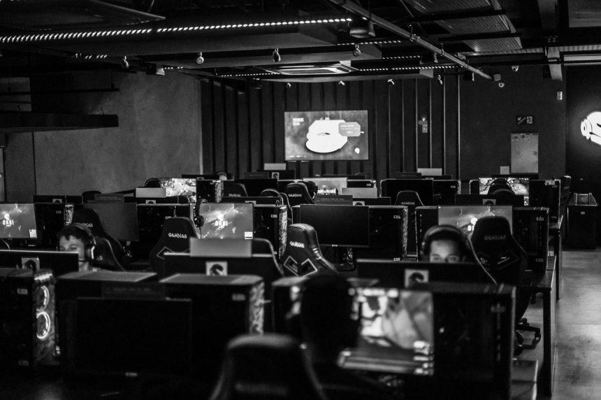 Pessoas jogam em computadores em um estúdio de jogos eletrônicos.