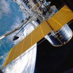 Espaçonave com painéis solares orbitando a Terra.
