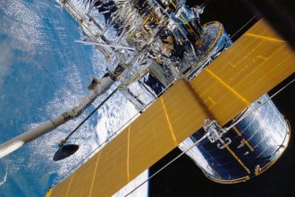 Espaçonave com painéis solares orbitando a Terra.