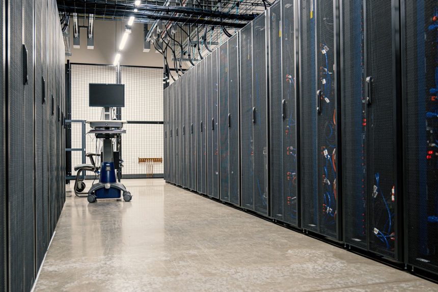 Armários metálicos com servidores, dispositivos de rede e cabos em um data center moderno