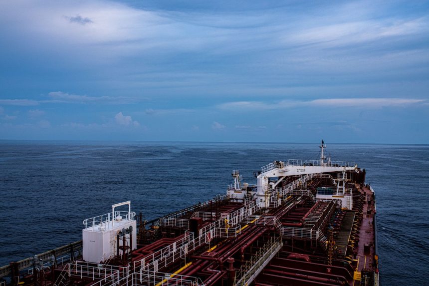 Vista aérea de um grande navio cargueiro navegando em alto-mar sob céu nublado.