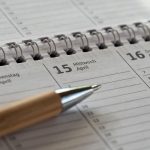 Calendário e materiais usados para organizar datas e compromissos.